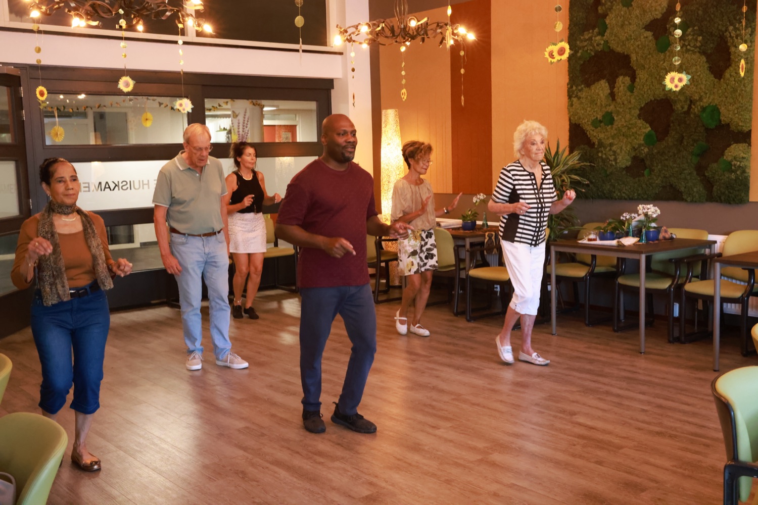 De groep danst samen in een lijn in de Emtinckhof