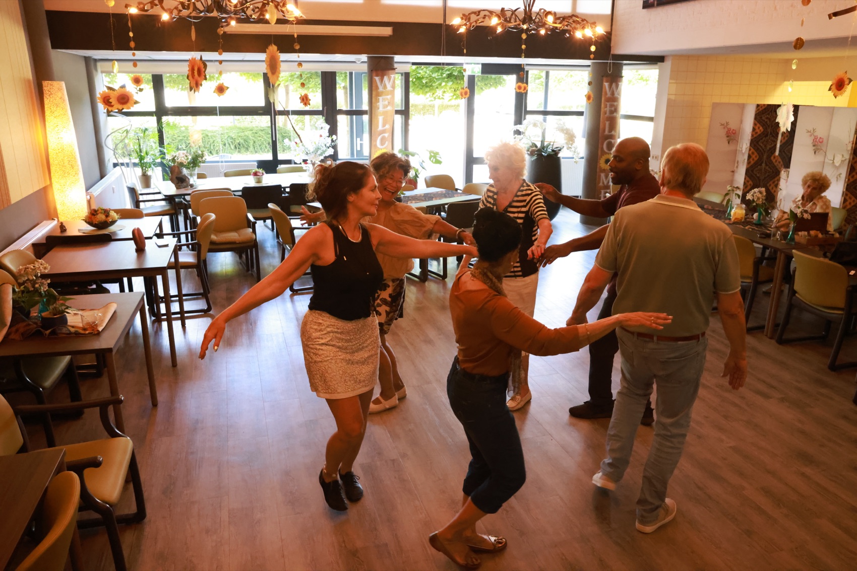 De MoMambo-groep danst samen in een kring in de Emtinckhof