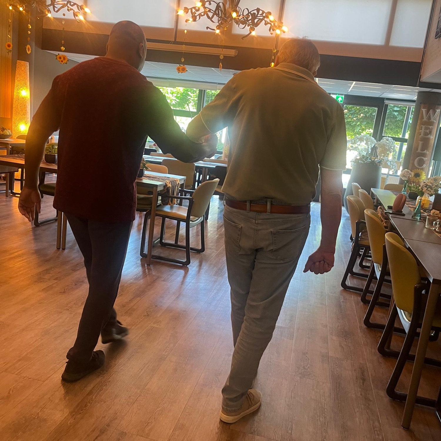 Twee heren dansen samen de pas in de Emtinckhof